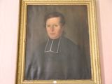 portrait d'un homme en habits sacerdotaux, dans un cadre doré, accroché à un mur rose