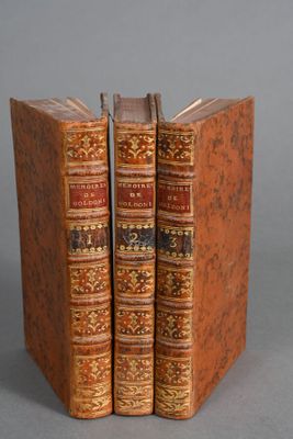 two old books sitting on top of each other on a table