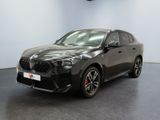 une voiture noire garée dans un showroom devant un mur blanc