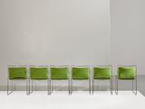 four green chairs sit in a row on a white platform