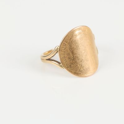 the gold ring is shaped like an oval with a hammered surface