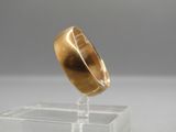 a close up of a gold ring on a clear stand