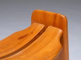 pair of wooden chairs with curved legs against a gray background