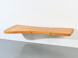 une étagère en bois fixée au mur au-dessus d'un lavabo
