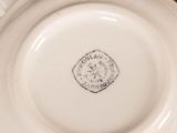 a close up of a white plate with a stamp on it