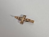 a small gold cross on a white surface