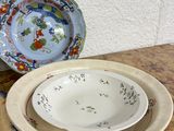 several plates and bowls are sitting on a table with a wall in the background