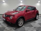 the red nissan juke suv is parked in the garage