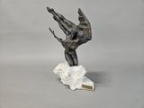 bronze sculpture of a man on a rock with a knife in his hand