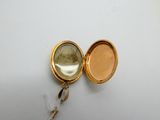 a gold locke with a picture of a woman inside of it