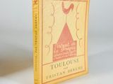 an old book with a yellow cover sitting on a white surface