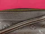 a close up of a louis vuitton bag on a pink background