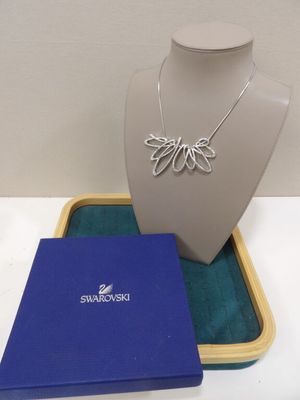 Collier plaqué argent avec une boîte bleue posée sur une table blanche