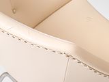 beige leather chair with metal legs and a buttoned back
