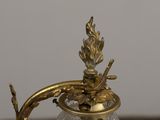 a glass vase with a gold decoration on top of it