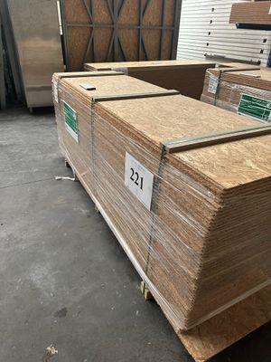 Plusieurs piles de cartons sont empilées les unes sur les autres dans un entrepôt