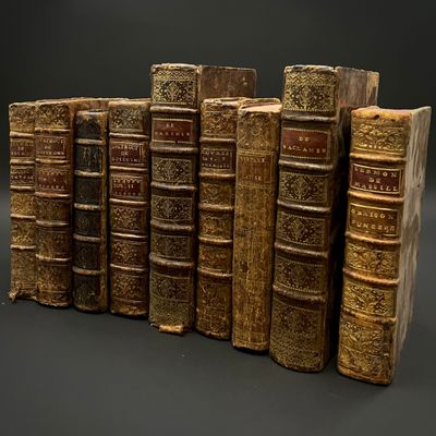 Plusieurs vieux livres sont alignés sur fond noir