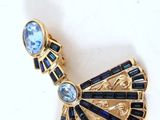 a close up of a brooch with a blue stone in it