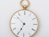 une montre de poche en or avec des chiffres romains sur le cadran