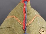 a close up of a green hat with a tassel on it