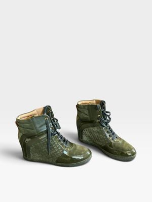 une paire de chaussures vertes posées sur une surface blanche