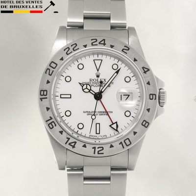 a close up of a watch on a white background with a red second hand