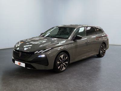 La voiture grise est garée dans une grande pièce au sol noir.