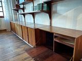 a desk and shelves in a room with wood flooring