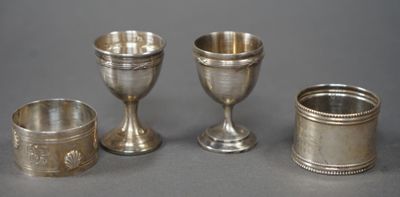 trois gobelets et tasses en argent posés sur une table