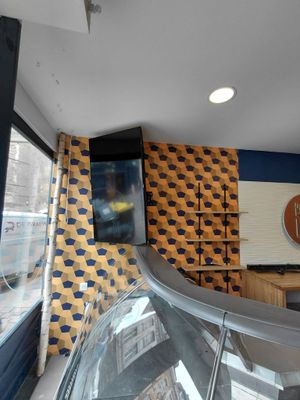 une vitrine en verre bombé dans un magasin, avec une horloge accrochée au mur