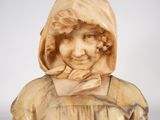 an antique carved bust of a woman with a hood on her head