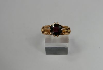 a close up of a gold ring with a garnetite stone