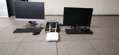 deux écrans d'ordinateur, un clavier et une souris posés par terre