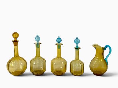 quatre vases en verre jaune avec un couvercle bleu et une anse bleue