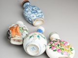 four small chinese vases sitting on top of a white table