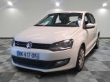 the white volkswagen polo is parked in a room with a checkered floor