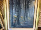 Deux tableaux encadrés représentant des arbres dans une forêt sont posés sur une table.