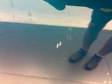 a person standing on a tiled floor holding a surfboard