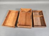 three wooden boxes are lined up on a gray surface