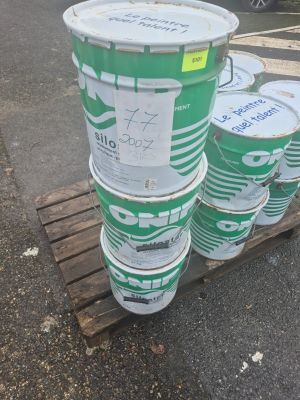plusieurs seaux de peinture posés sur une palette dans un parking