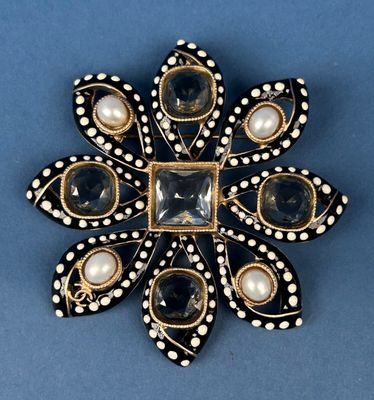 a black and white broochle with pearls and pearls