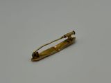 an image of a gold pin on a white surface