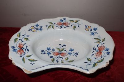 une assiette blanche décorée de fleurs bleues et orange
