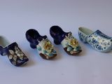 cinq sabots miniatures ornés de fleurs, posés sur un fond blanc