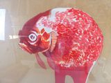 painting of a red fish in a glass case on a wall