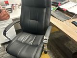 a black office chair sitting in front of a computer desk