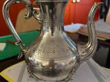 a silver tea pot sitting on top of a piece of paper