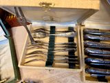 many forks and spoons in a box on a table