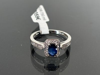a picture of a ring with a sapphire and diamonds on it