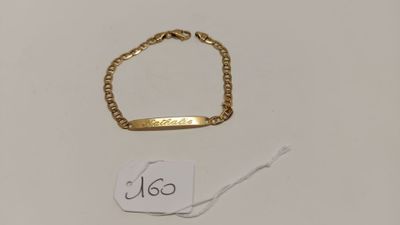 un gros plan d'un bracelet en or et d'une étiquette sur un fond blanc